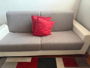 a red pillow sitting on a couch in a room at EDO'S HOME in Lonate Pozzolo