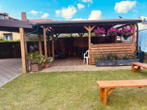 a wooden pergola with a table and a bench at Dom wczasowy Riviera in Ustronie Morskie +6 photos