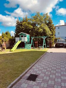 a playground with a slide and a house at Dom wczasowy Riviera in Ustronie Morskie
