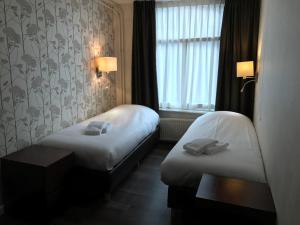 A bed or beds in a room at Hotel Carillon