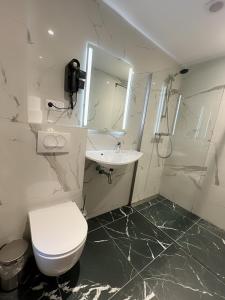 a bathroom with a toilet and a sink and a mirror at Hotel 2000 Valkenburg in Valkenburg +46 photos