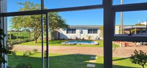 a view of a yard from a window at Volgenoeg Self Catering Family Unit in Oudtshoorn