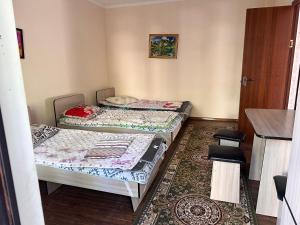 two beds in a small room with a rug at Достук in Bosteri