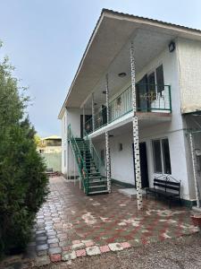 a building with a staircase and a balcony with a porch at Достук in Bosteri +3 photos