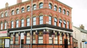 a large brick building on the corner of a street at Trivelles Liverpool in Liverpool