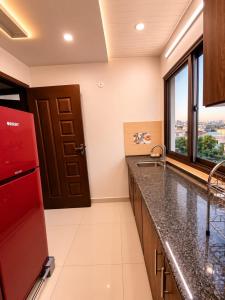 a kitchen with a sink and a red refrigerator at Family-Friendly Luxury Apartment Home Away From Home in Islamabad