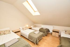 a attic bedroom with three beds and a skylight at Rancho Adama - wypoczynek w sercu Beskidów! in Pewel Ślemieńska
