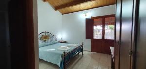 a small bedroom with a bed and a door at Bungalow Coronas in Bonorva