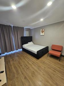 a bedroom with a bed and a chair at Prime's Home in Nevendon
