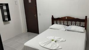 a bedroom with a white bed with a towel on it at Delta Hotel Nova Mutum in Nova Mutum +10 photos