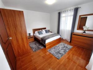a bedroom with a bed and a wooden floor at Alojamento Local - El Paraiso in Câmara de Lobos