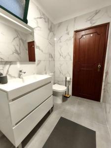 a white bathroom with a sink and a toilet at Alojamento Local - El Paraiso in Câmara de Lobos +16 photos