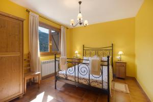 a bedroom with a bed with yellow walls and a window at Casa Montenegro Las Colladas in Las Colladas