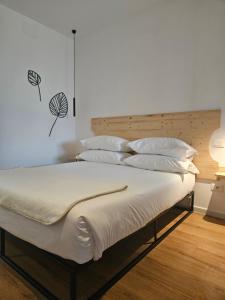 a bedroom with a bed with white sheets and pillows at Dolcevita guest house in Torreano