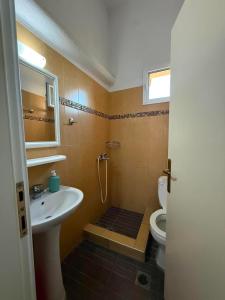a bathroom with a sink and a toilet at Themis Rooms in Nea Vrasna
