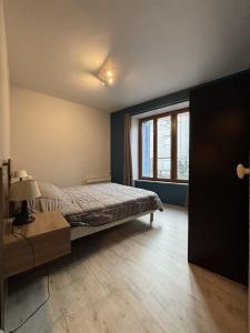 a bedroom with a bed and a large window at L'estaou in Lavoûte-Chilhac