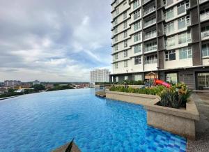 a large swimming pool in front of a building at Crystal Studio Apartment D'Perdana in Kota Bharu