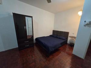 a bedroom with a bed and a dresser and a mirror at AymanSyahir in Mukah
