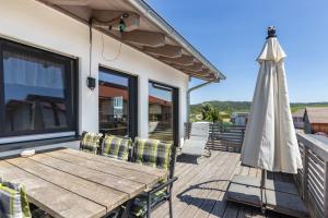 a patio with a wooden table and an umbrella at Hubertus in Dietingen