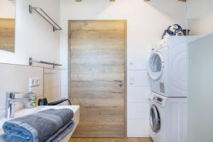 a bathroom with a sink and a washing machine at Hubertus in Dietingen