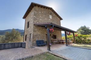 a stone building with a patio and a table at Casa Montenegro Las Colladas in Las Colladas