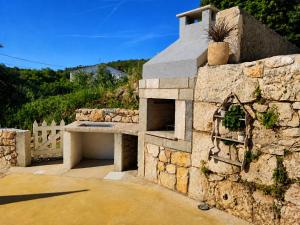 an outdoor oven with a stone wall at Holiday home Brseč in Mošćenička Draga
