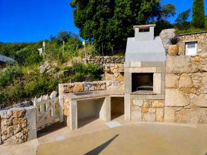a stone pizza oven in a stone wall at Holiday home Brseč in Mošćenička Draga