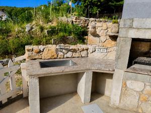 a stone counter with a sink in front of a stone wall at Holiday home Brseč in Mošćenička Draga
