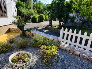 a garden with a white fence and some plants at Holiday home Brseč in Mošćenička Draga +20 photos