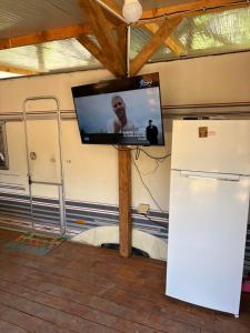 a flat screen tv on a wall with a refrigerator at Divoto Zove in Tsarevo
