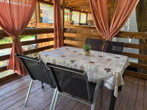 a table and chairs on a deck with a table and curtains at Divoto Zove in Tsarevo