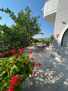 a patio with a table and red flowers at Agron S in Vlorë