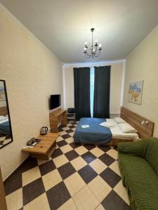 ein Schlafzimmer mit einem Bett und einem Schachbrettboden in der Unterkunft Mini hotel Non-Stop in Kiew