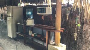 a kitchen with a microwave on a shelf next to a refrigerator at Guarumbo in Bacalar