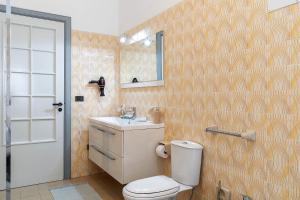a bathroom with a toilet and a sink and a mirror at Villa Anny in Avola +28 photos