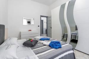 a bedroom with a bed with pillows and a mirror at Villa Anny in Avola