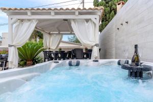a hot tub with a bottle of wine in it at Villa Anny in Avola