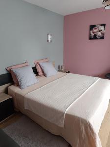 a bedroom with a large white bed with pillows at Un air de campagne climatisé - Cure thermale ou vacances in Saint-Loubouer