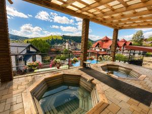 a patio with two hot tubs on a balcony at SPA Resort HeRICH in Bukovel