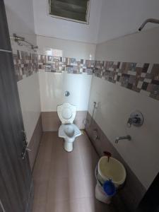 a bathroom with a toilet and a sink at Hotel MJ in Ujjain