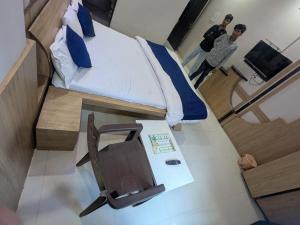 a small bedroom with a bed and a chair at Hotel MJ in Ujjain +25 photos