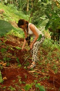 a woman standing in the woods with a shovel at Casinha da Roça Java in Santa Adelaide