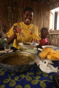 a woman eating food at a table with a child at Casinha da Roça Java in Santa Adelaide