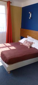 a bedroom with a bed with a red and blue wall at Domaine du Viaduc in Garabit