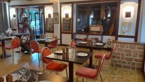 a restaurant with tables and chairs and a brick wall at Domaine du Viaduc in Garabit