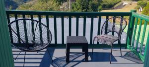 two chairs and a stool sitting on a balcony at Domaine du Viaduc in Garabit