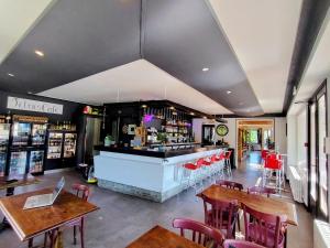 a restaurant with a bar and tables and chairs at Domaine du Viaduc in Garabit