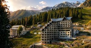 a hotel in the mountains with mountains in the background at Serene Resorts Naran in Naran