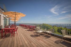a deck with tables and chairs and an umbrella at Hochblauen Hotel in Badenweiler +57 photos