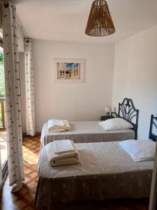 a room with two beds and a pendant light at Duplex T3 2 étoiles bord de lac 65mcarrés in Biscarrosse